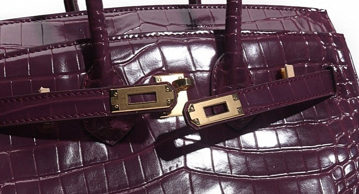 Luxury purple crocodile handbag featuring gold hardware and a textured finish, ideal for fashion enthusiasts and luxury accessory lovers.